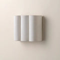 Vague fabric wave headboard sconce above a bed