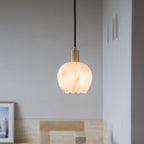 Petit Cuivré copper pendant lamp above a reading chair