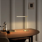 Articulé brass lamp styled on a reading table