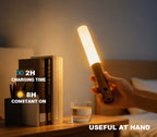Aplique LED extraíble sostenido en la mano como luz portátil junto a una mesilla de noche