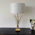 Cristalys faceted crystal table lamp illuminated on a console table